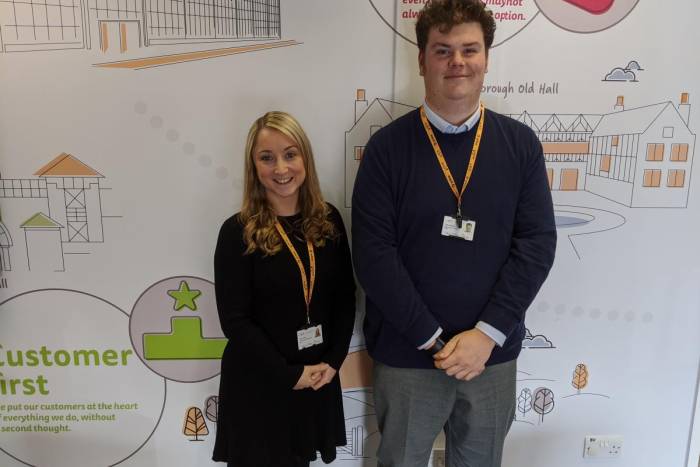 Two people standing side by side smiling