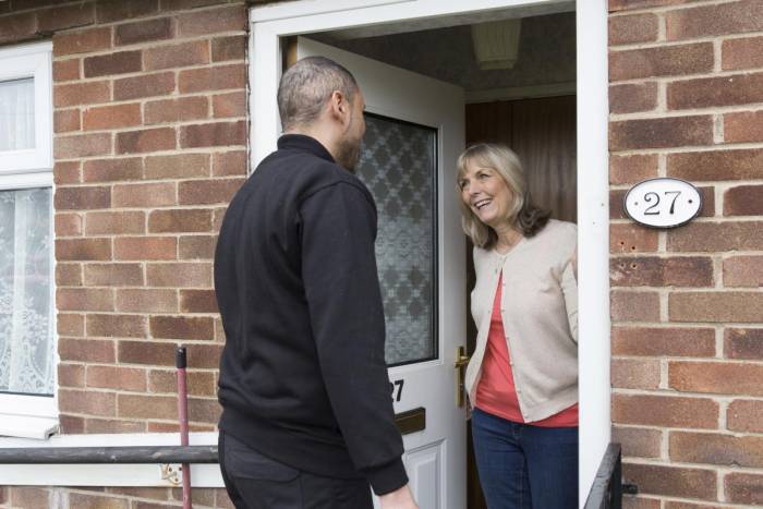 Woman greeting man at her front door