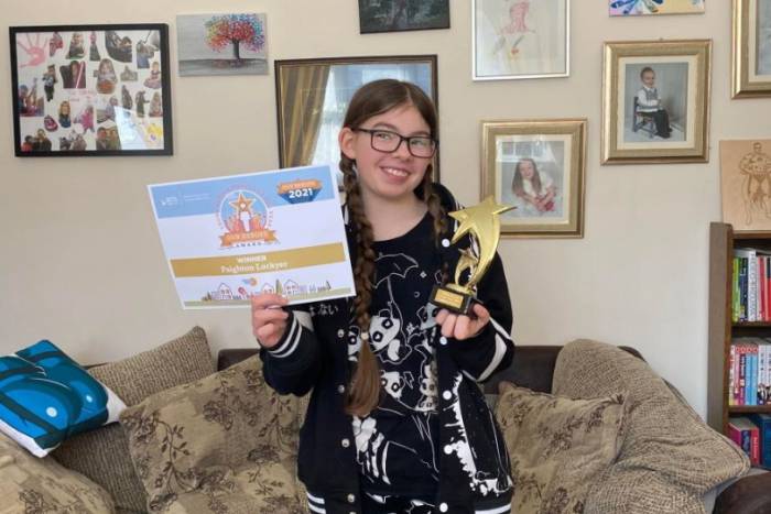 Young girl holding awards