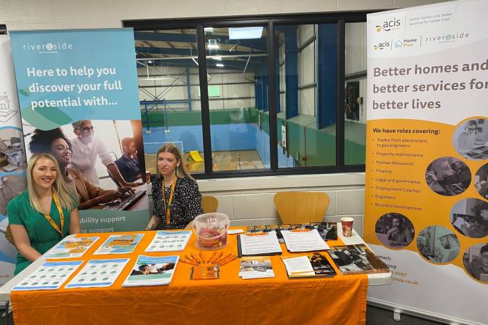 Two women sat behind a table 