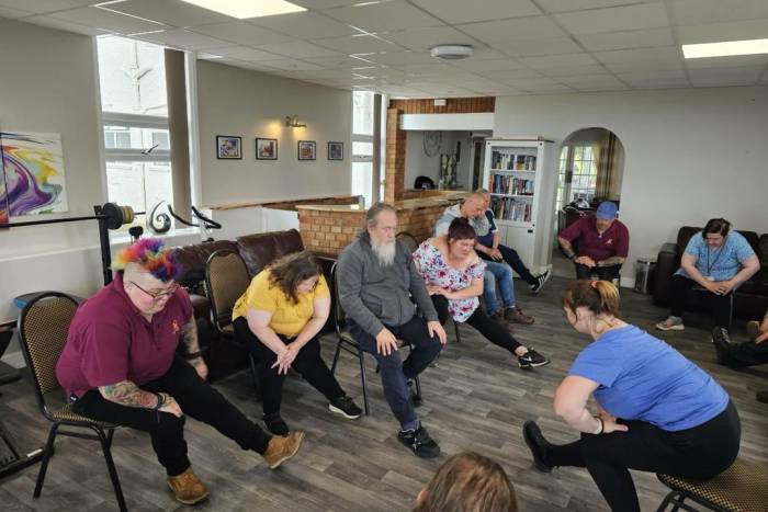 A group of people doing chair exercises