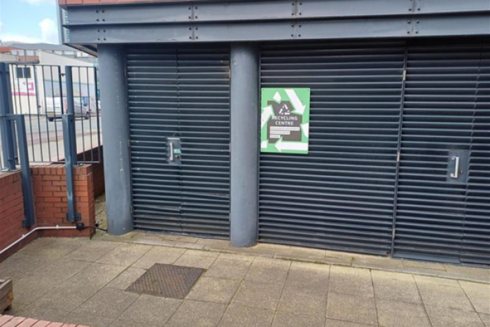 A door to a bin store with a sign saying recycling centre
