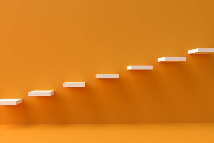 An orange wall with white stairs embedded in it 