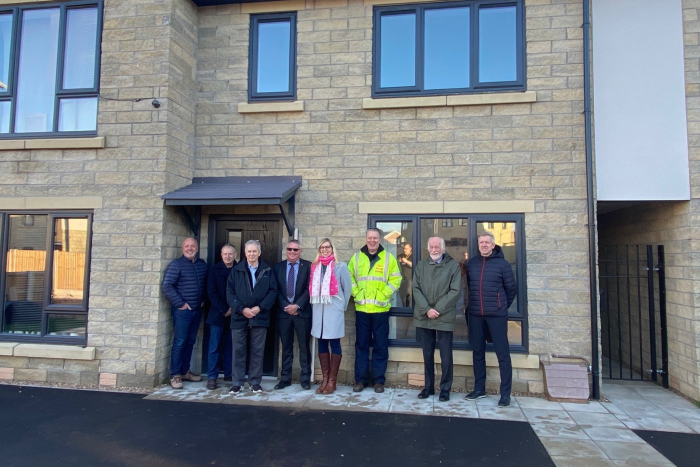 Group of people standing outside a new build house