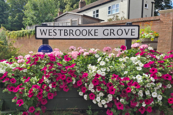 Westrbooke Grove street sign with flowers around it