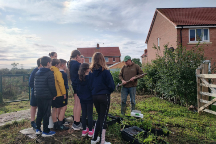 A group of children listening to a man talk 