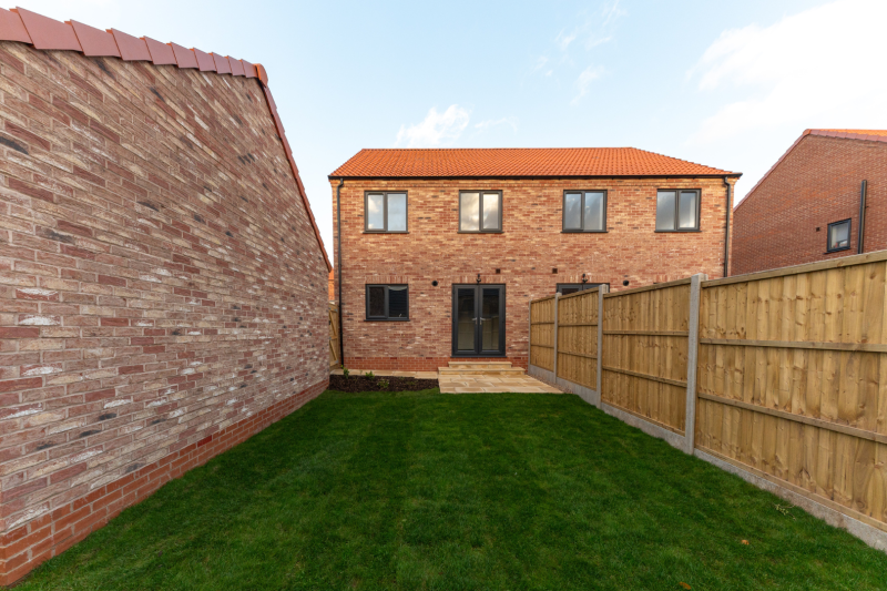 turfed garden looking towards a house