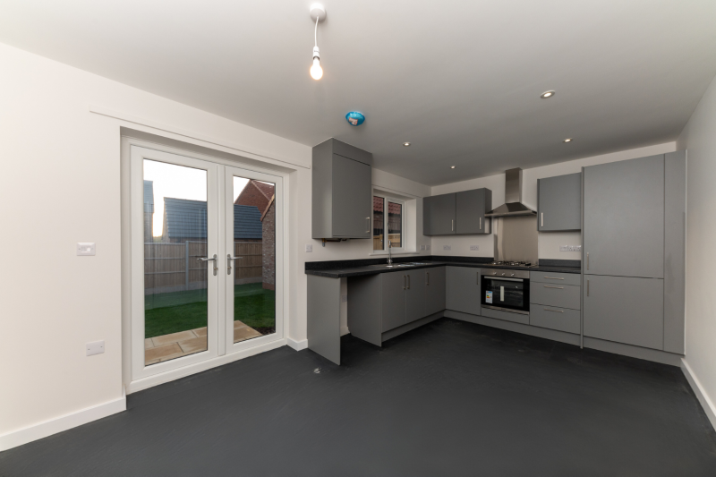 Kitchen diner with french doors out on to a turfed lawn