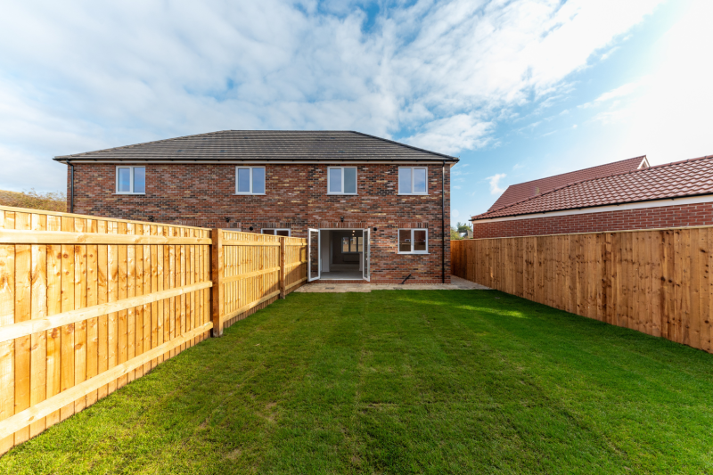 A turfed garden looking towards the house