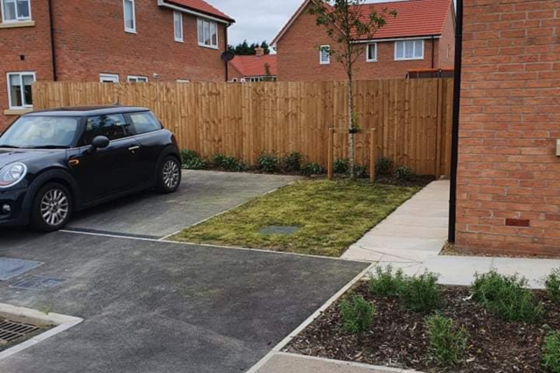 Car parking outside a house with a car parked