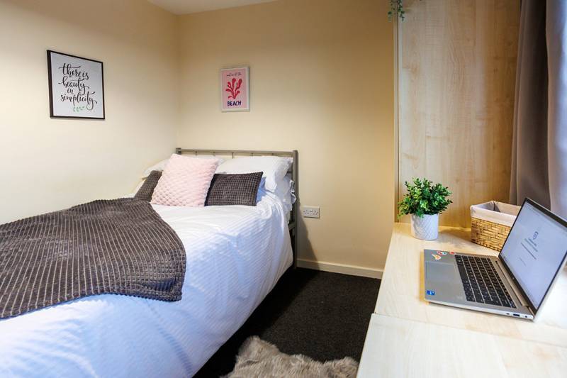 Student room with bed, desk and computer