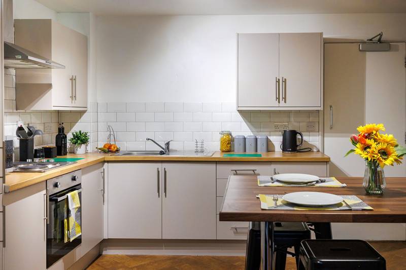 Shared kitchen with dining table and stools