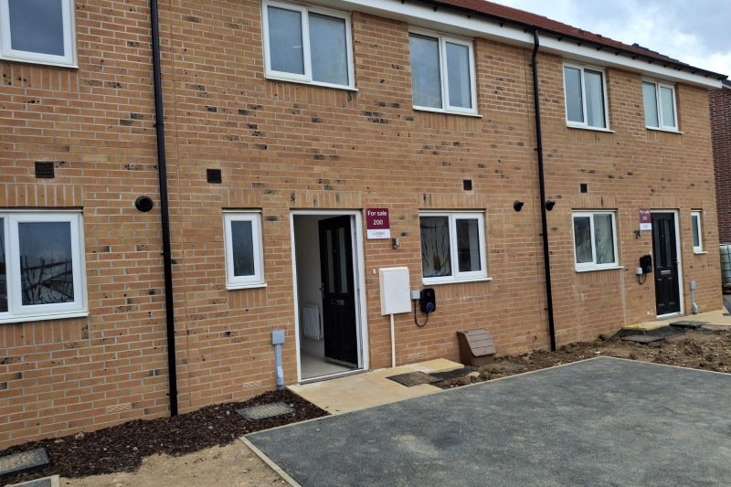 Front of a terraced row of houses with parking