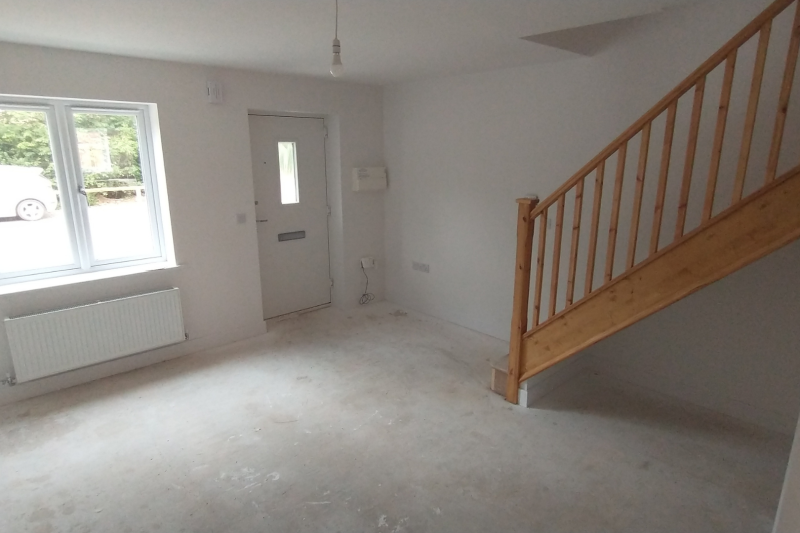 Empty room with stairs and front door