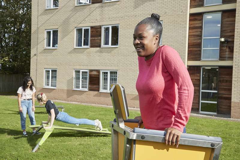 Student using outdoor gym equipment