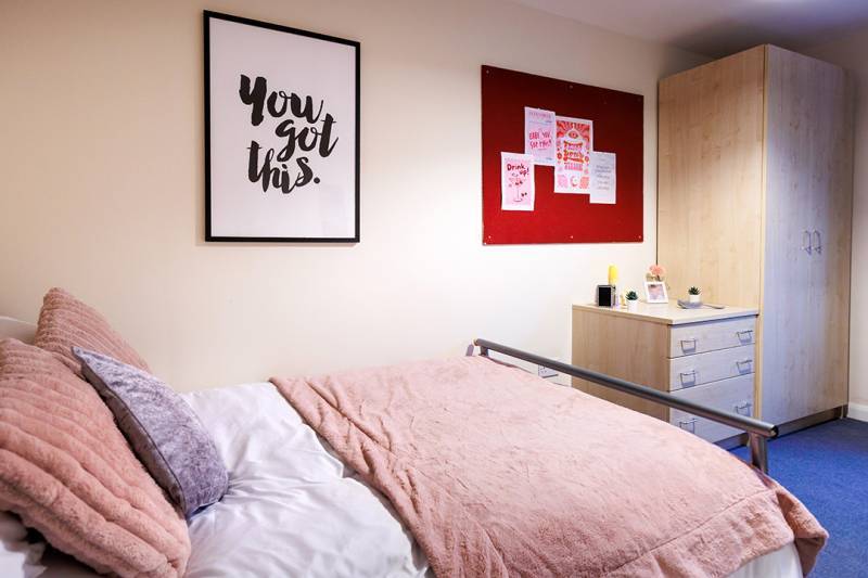 Student room with bed, drawers and wardrobe