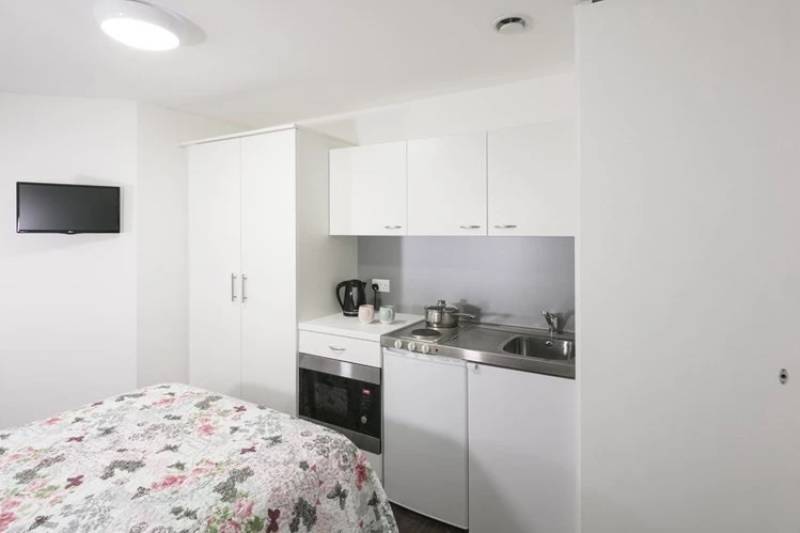 View of the studio kitchen with wardrobe, oven and sink
