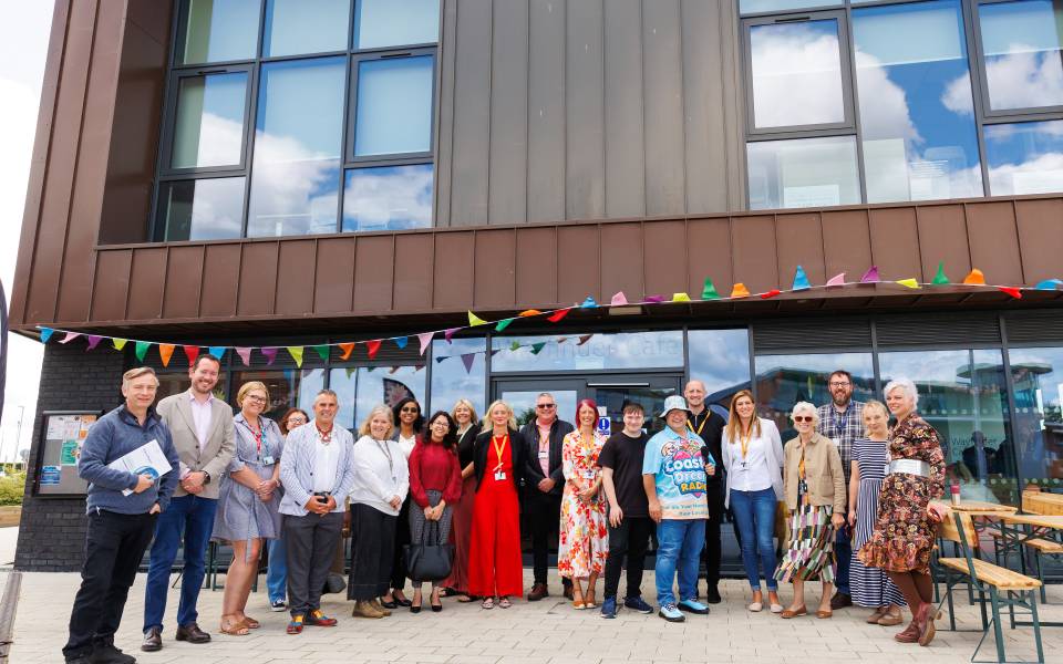 A group of people standing outside a modern community hub