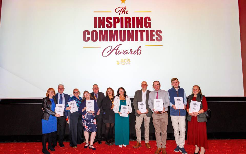 Group stood together smiling with awards and certificates