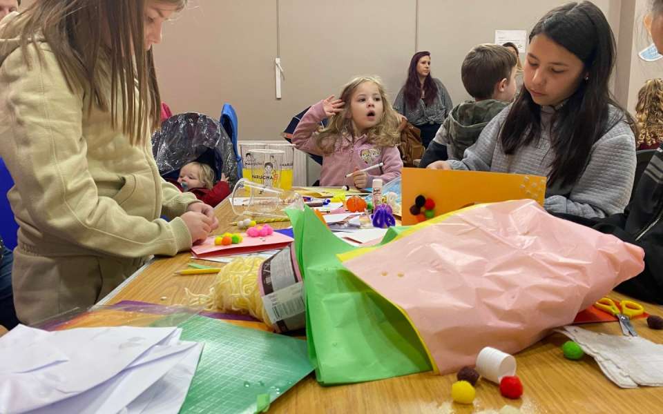Families around a table making craft decorations