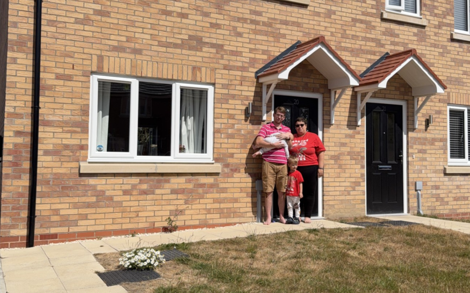 A family outside their shared ownership home bought through Acis Group