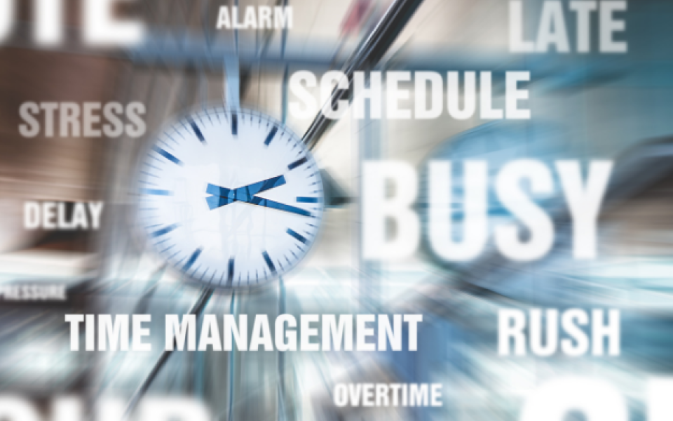 Clock with blurred background and text saying busy, time management, stress, delay