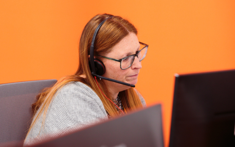 A woman speaking through a headset