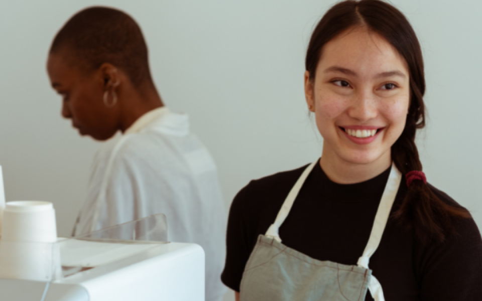 A woman in an apron smiling 