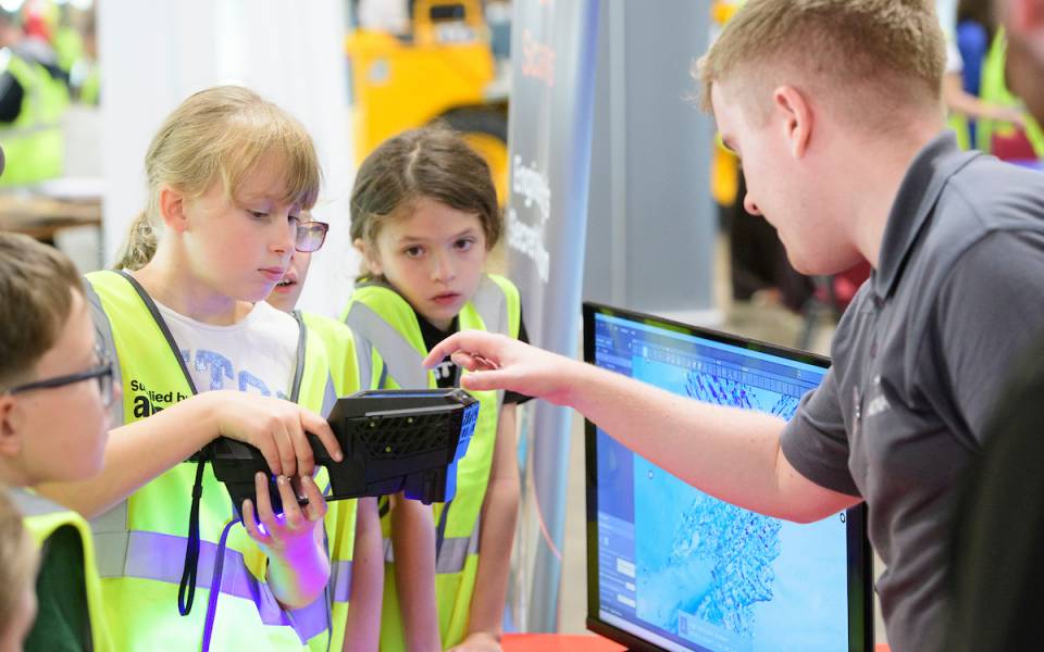 A group of children try using a laser scanner