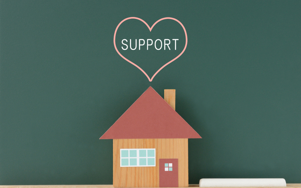 House made of cardboard with support written in heart above