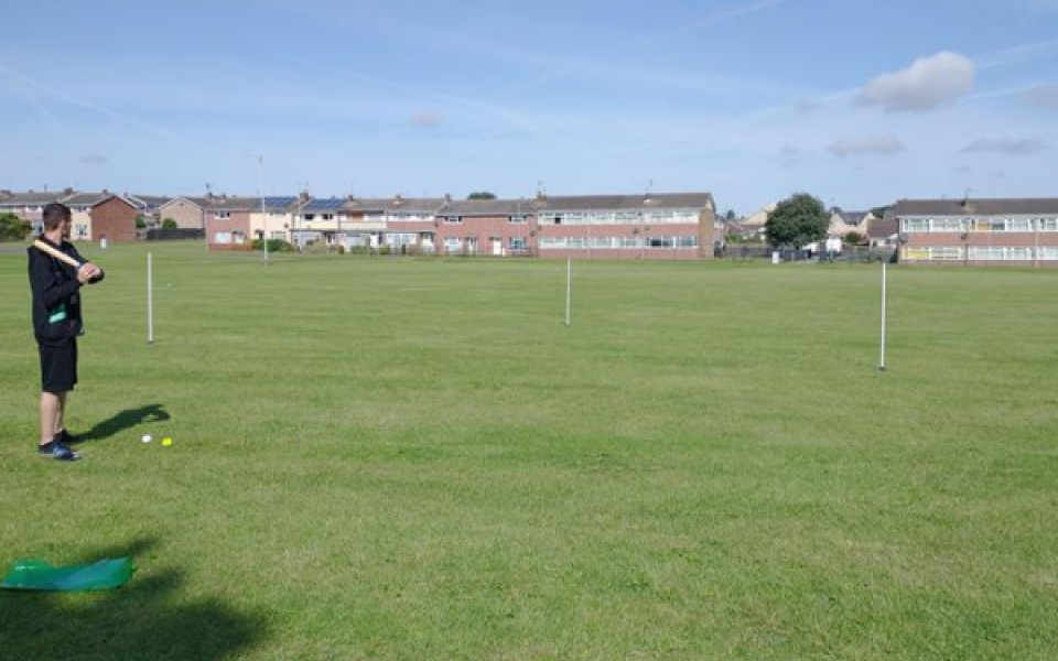 a man playing rounders in a field