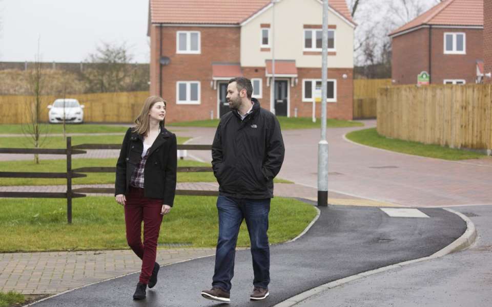 Two people walking through housing estate