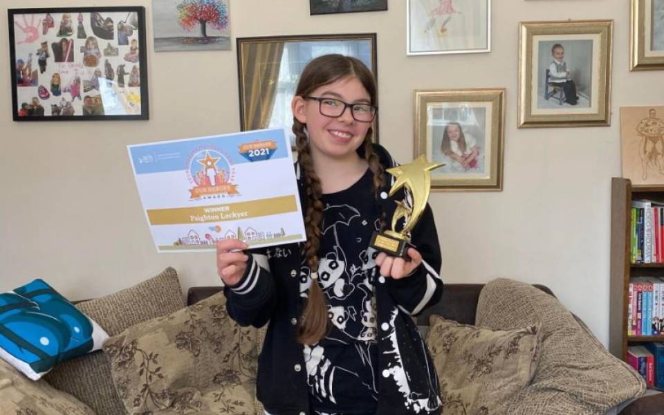 Young girl holding awards