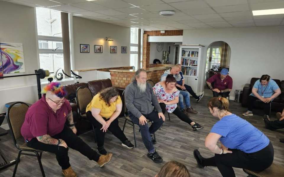 A group of people doing chair exercises