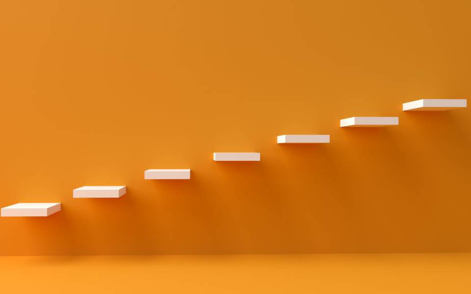 An orange wall with white stairs embedded in it 