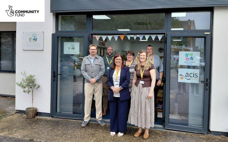A group of staff smile as they stand outside of a new Wellbeing and Learning Hub