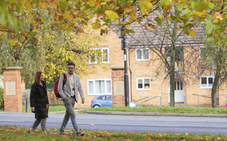 Two people walking through a neighbourhood