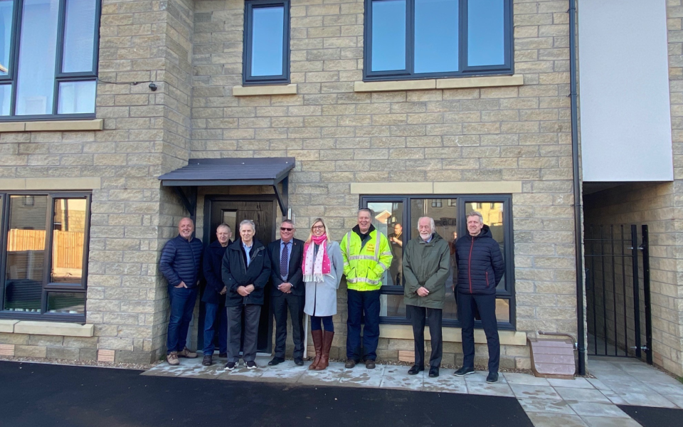 Group of people standing outside a new build house